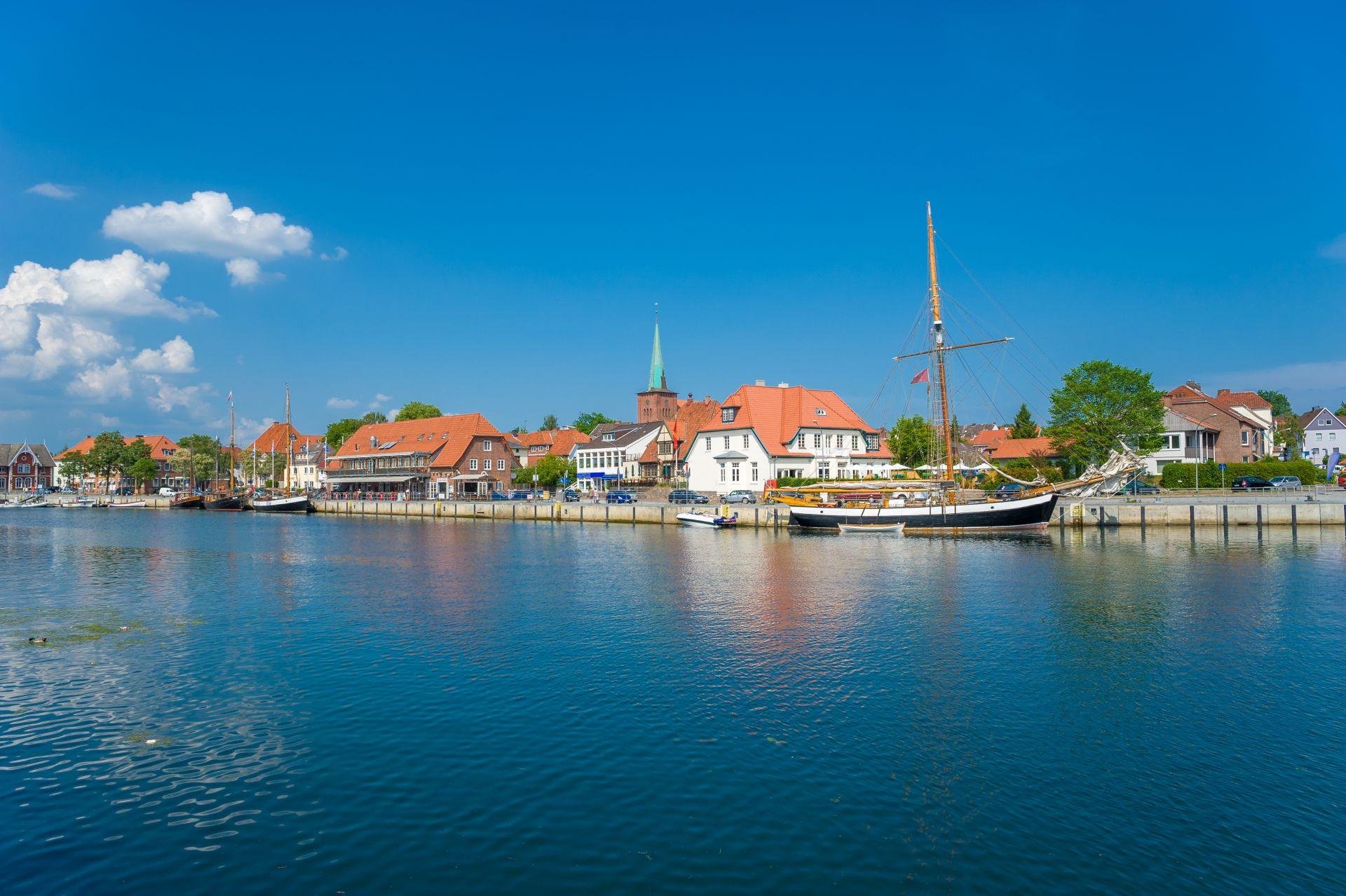 Hafen von Neustadt in Holstein mit historischen Segelschiffen und Altstadthaeusern – beliebtes Ziel fuer Ferienimmobilien